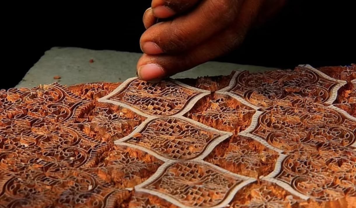 Artisan hand-carving a traditional wooden printing block