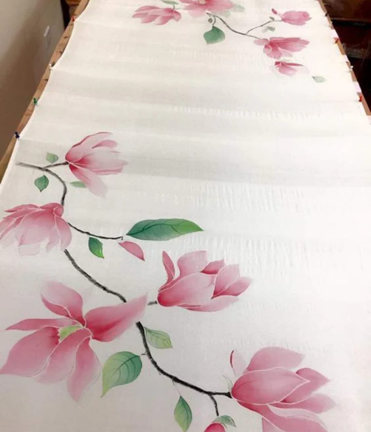 Kolkata artisan hand-painting magnolia motifs on a silk sari