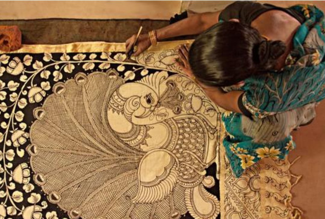 Artisan hand-painting a peacock motif on Tussar silk